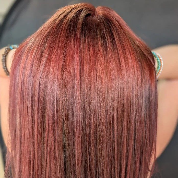 Back view of straight, shiny rose copper hair on a real client