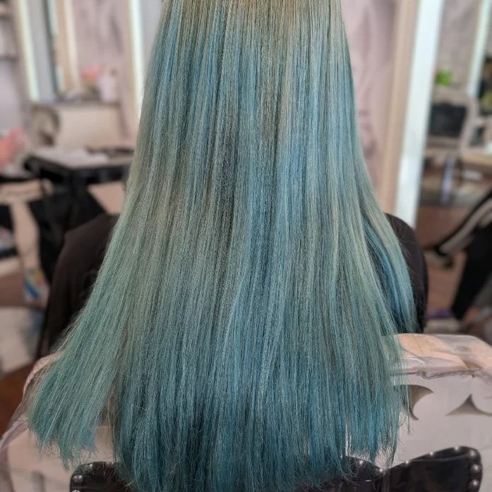 Before: long, straight hair seen from behind in a faded, patchy teal