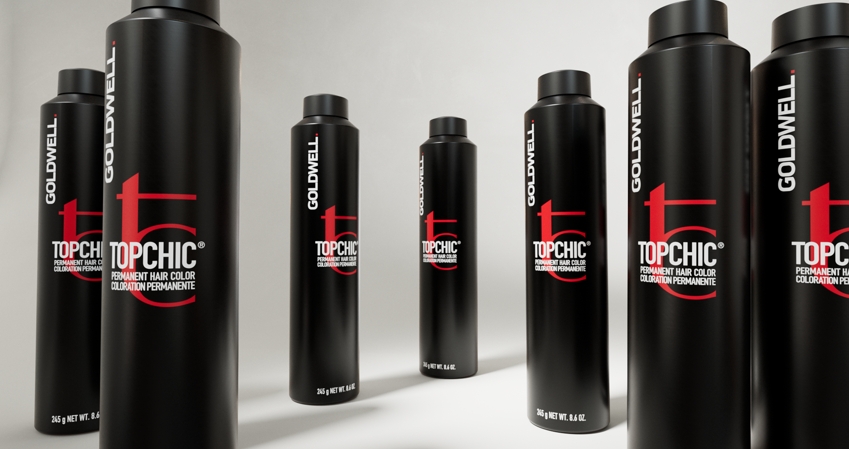 Product photo of Goldwell Topchic permanent color bottles standing on a pale gray studio floor